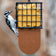 Tail Prop Suet Feeder, Brown with a Downy Woodpecker clinging, features a durable black suet cage for easy feeding and balance, holding one suet cake.