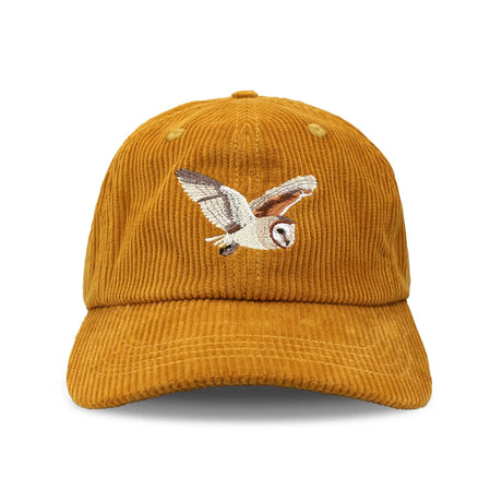 Barn Owl Corduroy Hat, Amber features a mustard-yellow corduroy with an embroidered barn owl in flight, adjustable strap, and unstructured 6-panel crown.